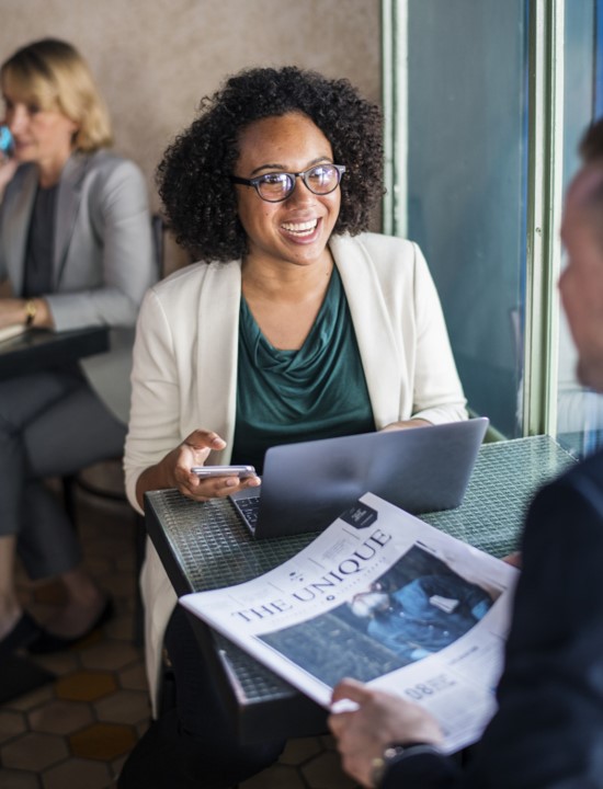 African-american woman working on laptop in conversation smiling