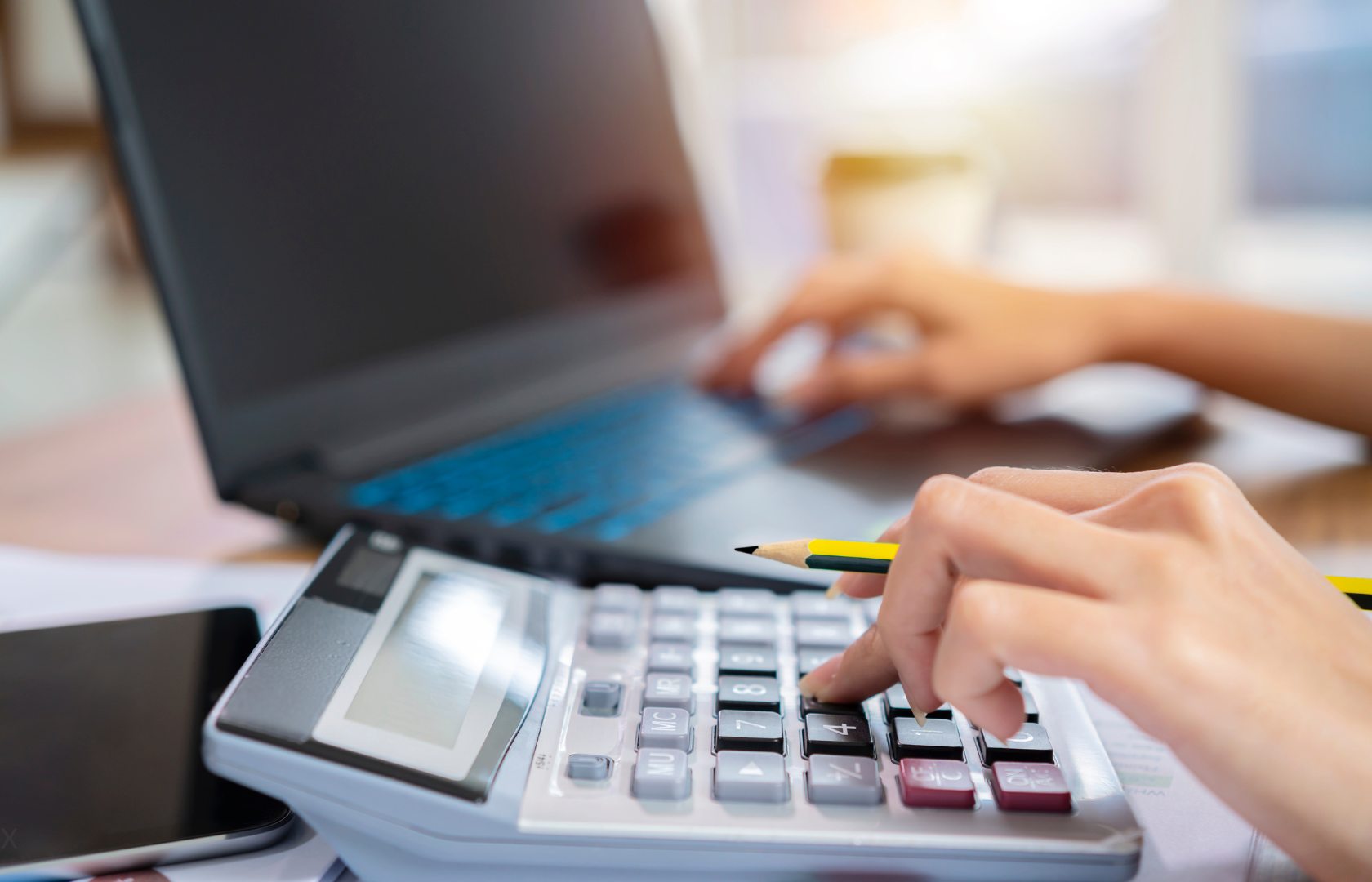 Person planning Person using laptop and calculator to plan.